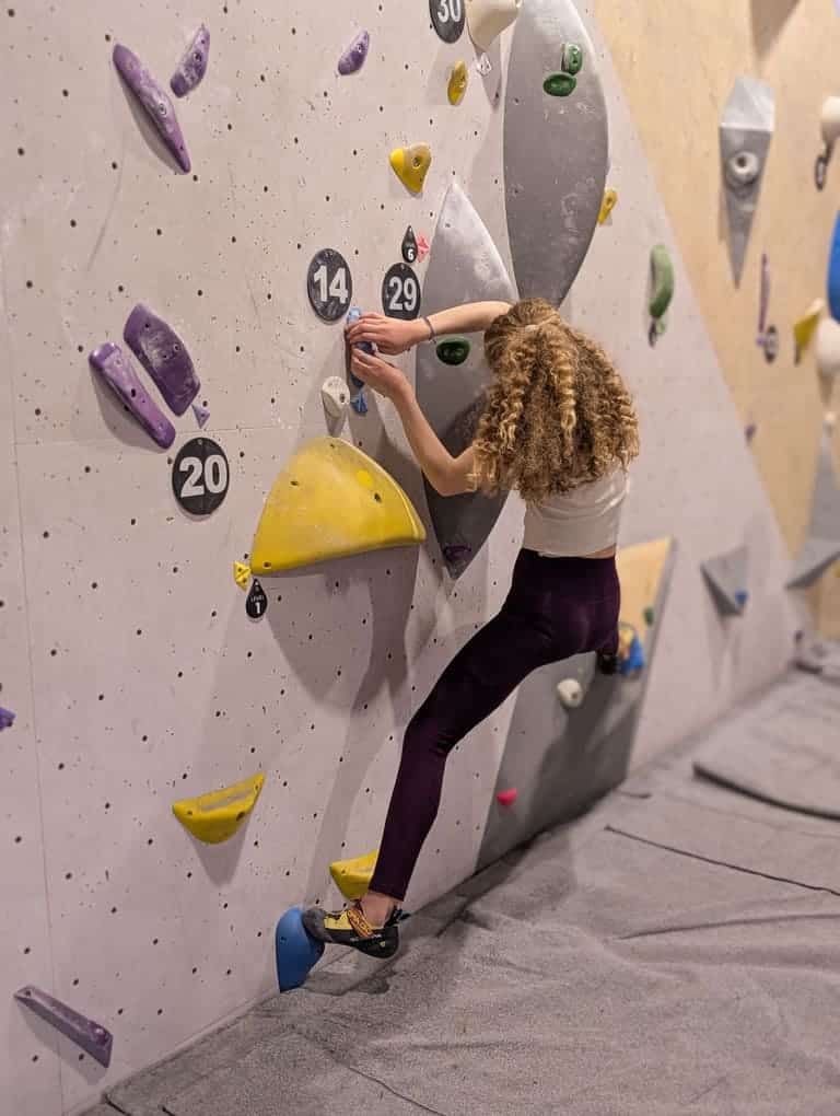Femme pratiquant l’escalade de bloc au Triangle à Bercy, Paris 12