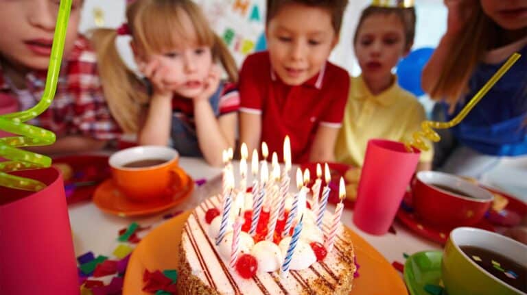 Photo d’illustration : enfants autour d’un gâteau d’anniversaire aux bougies allumées
